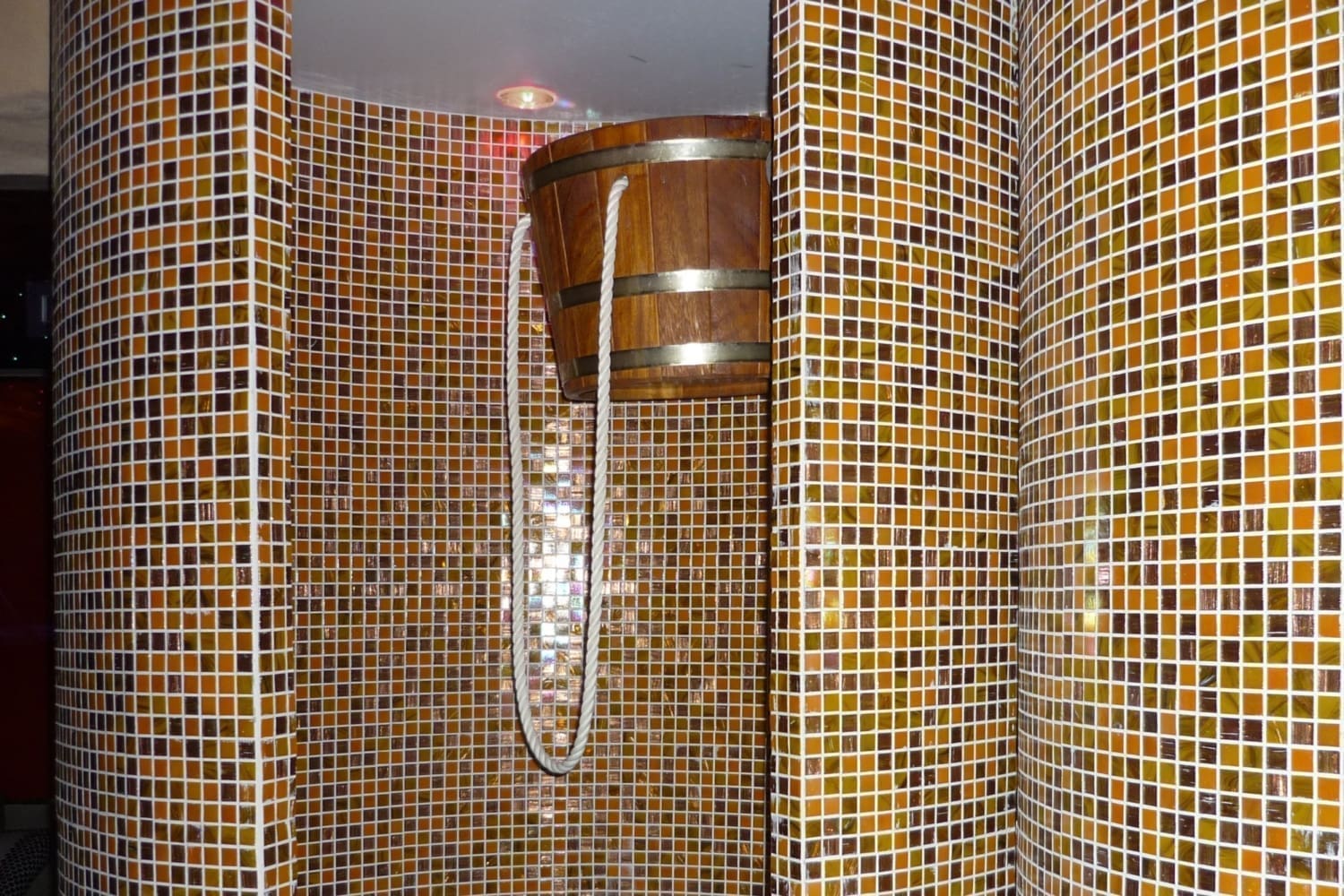 Ducha de contraste con cubo de madera en instalación de gresite.