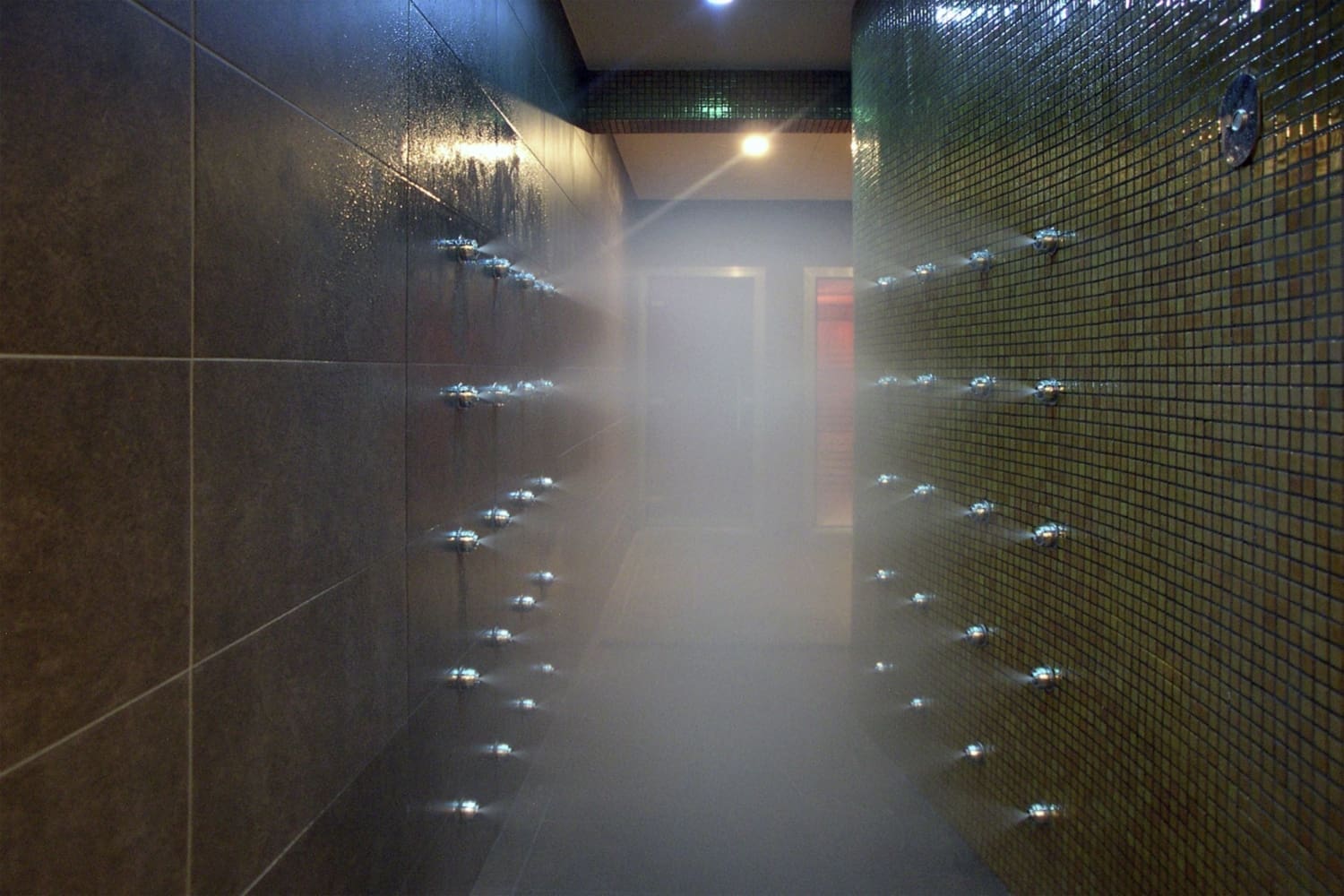 Pasillo de ducha de obra con pared de mosaico