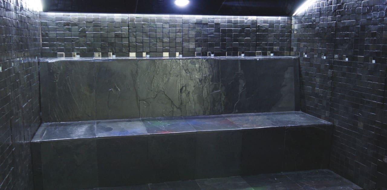 Hammam de piedra, de colores oscuros con un diseño muy elegante.