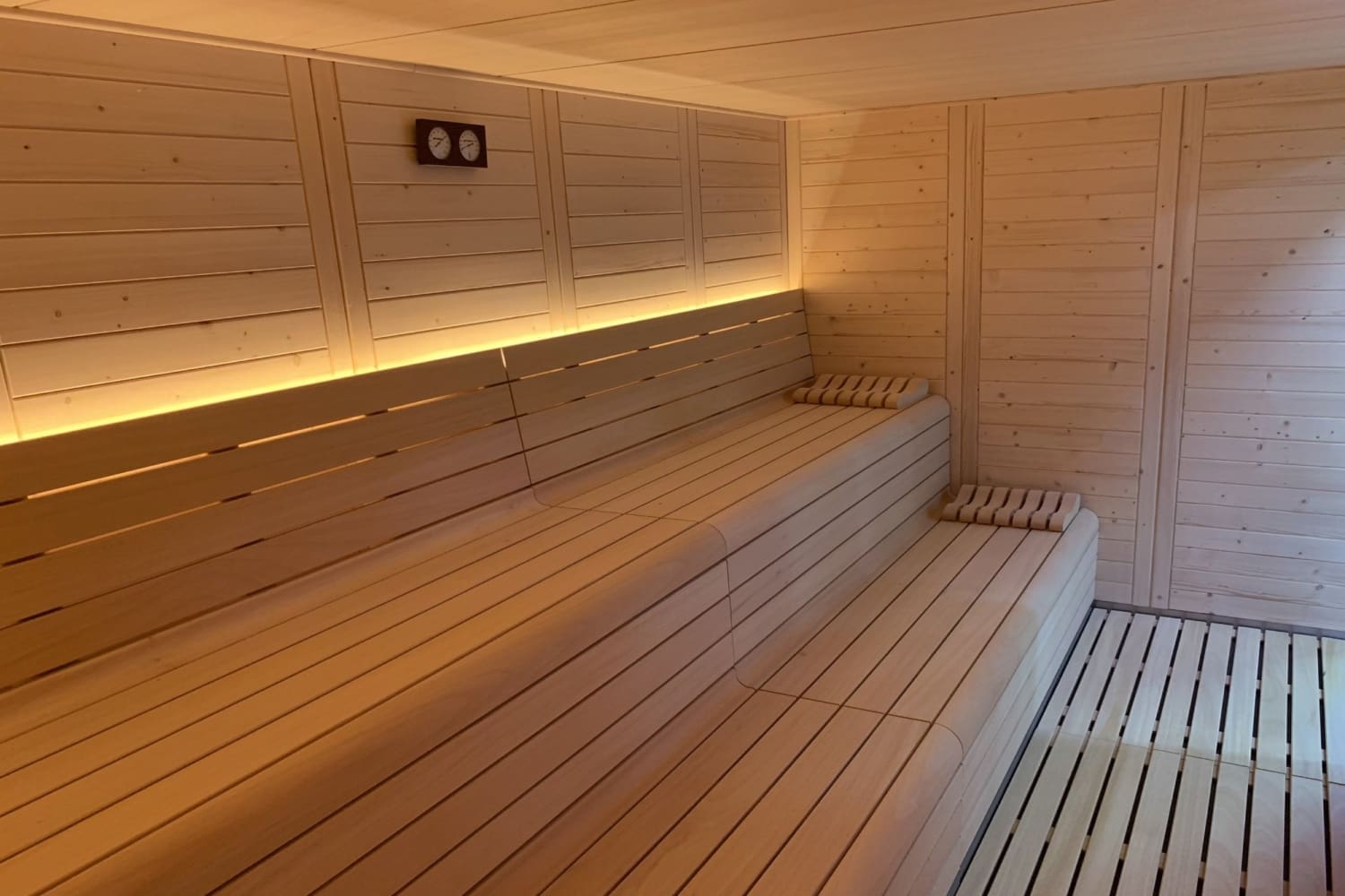 Sauna Barcelona con madera de Abeto, con luces led, adaptada al espacio y diseño de la marca.